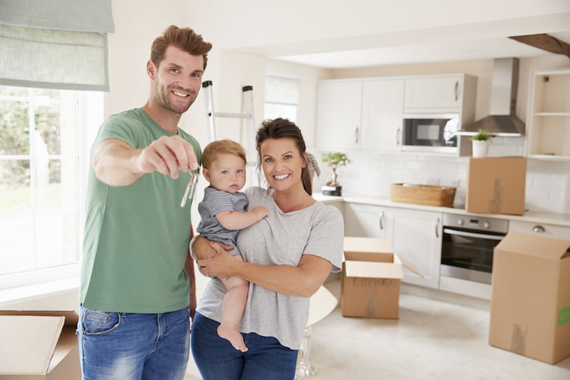 Portrait Of Family With Baby Holding Keys On Moving In Day